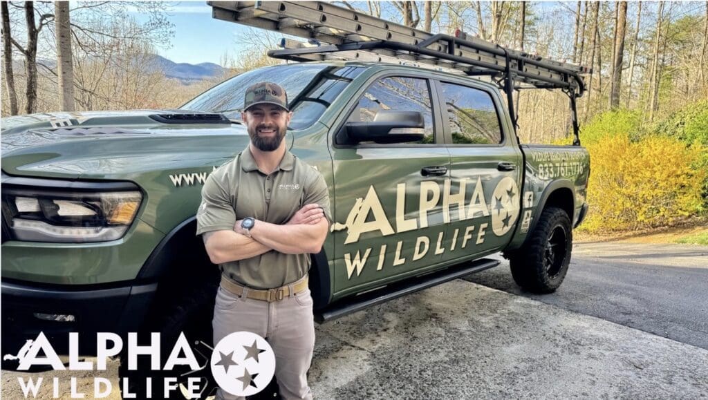 Alpha Wildlife Knoxville Technician standing next to his branded truck